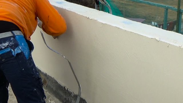 Worker with smash sponge spatula performs plaster up