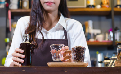 Girl barista bartender waiter in uniform making coffee, Girl barista bartender waiter in uniform making coffee,Asian Barista woman Cold brew coffee in glass bottle to a cup glass in the coffee shop. p