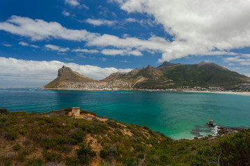 View from Chapman's Peak Drive over the turquoise, crystal clear Water of the Hout Bay, south of Cape Town, South Africa, on a sunny day with blue Sky