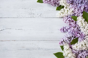 Fotobehang Een houten ondergrond met bloeiende lila takken © tachinskamarina
