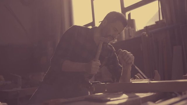 Handsome man in his fourties working with wood in his workshop