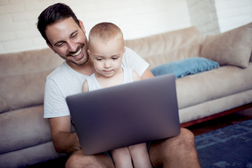 Father and son watch cartoons on the laptop.