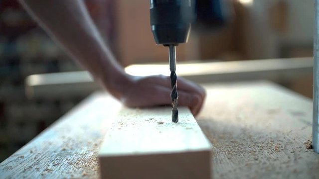 Handsome man in his fourties working with wood in his workshop