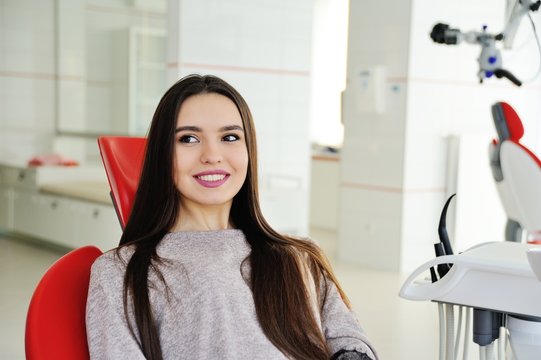 A pretty girl patient in a dental chair awaits a dentist. Tooth Health