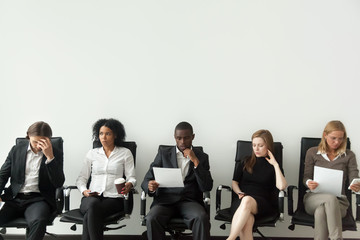 Rivalry at job interview concept, applicant walking in room while envious curious multiracial...