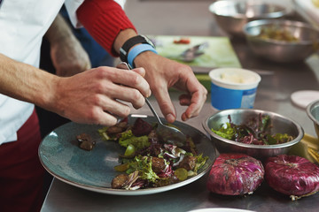 Chef cooking juicy beef steak at restaurant kitchen