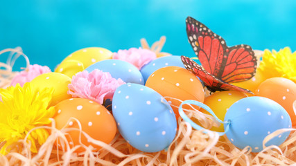 Happy Easter ornaments, eggs and spring flowers on a blue and white background.