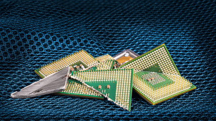 Broken computer processors on blue hexagonal textured mesh. Artistic background from the shards of...