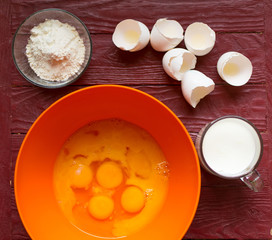 Ingredients for pancakes - broken eggs, flour, milk.