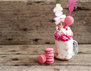 crazy shake. Freakshake from pink smoothie, cream with marshmallos, macarons and colorful candies