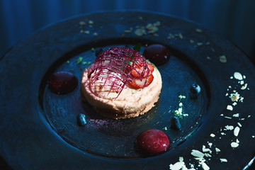 Lemon cheesecake with berry spheres served at modern restaurant