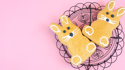 Happy Easter overhead with Easter Bunny cookies and decorations on a wood table background and copy space.