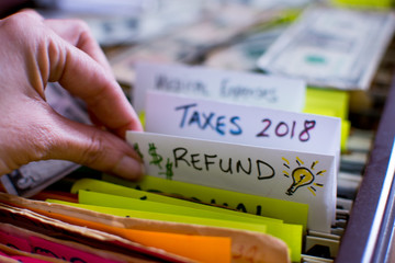Tax Credit and Income Tax Refund conceptual Photography woman pulling file out of filing cabinet...