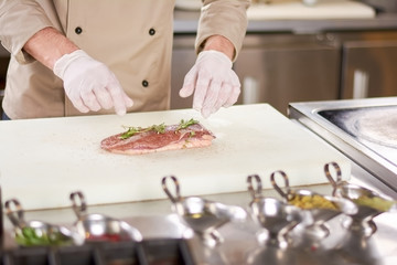 Duck raw breast with rosemary. Raw fillet of duck breast served with rosemary and ground pepper. Chef cooking meat at work.