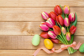Spring easter tulips in bucket on wooden vintage background.