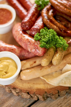 Close up of grilled sausages with mustard. Octoberfest traditional food. Delicious grilled meat at european restaurant.