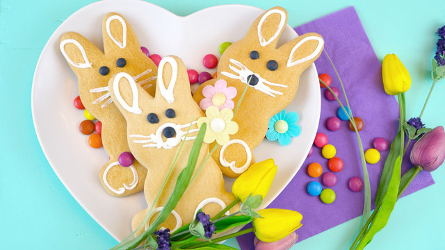 Happy Easter overhead with Easter Bunny cookies and decorations on a wood table background