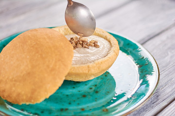 Mushroom cream soup in bread pot. Chef putting fried chopped mushrooms in creamy mushroom soup. Delicious dinner on plate.