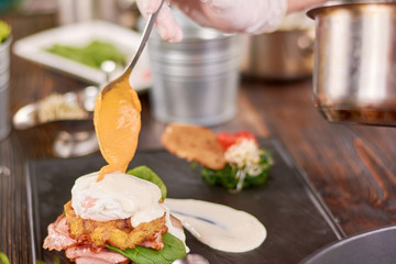 Benedict pouring with mustard. Cooking delicious benedict in restaurant. Tasty benedict with ham.