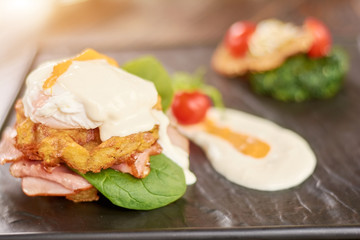 Appetizing benedict with ham. Fresh cooked benedict in restaurant. Delicious dinner on table.