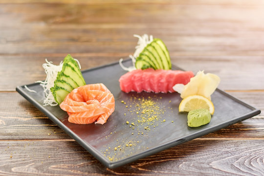 Raw salmon and tuna in japanese style. Raw tuna and salmon on black plate. Delicious japanese food.