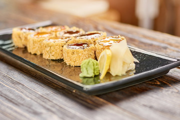Sushi roll set at restaurant. Unagi sushi rolls on plate. Traditional japanese food on wooden table.