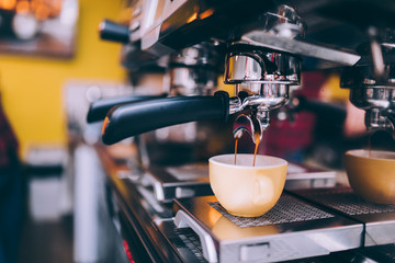 Details of barista preparing fresh espresso on industrial brewing machinery