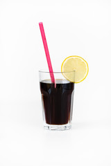 Glass of coke or other dark, sugary soda beverage with slice of lemon and pink straw on white background