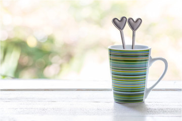 cup on wooden table with spoon shape heart