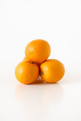 Stack of fresh, ripe, sweet and juicy, organic oranges on white background