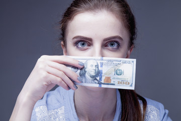Business Woman covering her mouth with a dollar banknote as symbol of bribery, cheating, financia and l  political  manipulation.