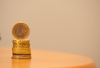Close up of stacked coins and 1 euro on top