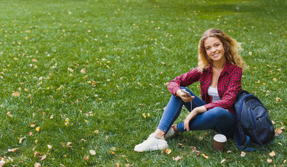 Fototapeta premium Beautiful woman sitting and using smartphone outdoors
