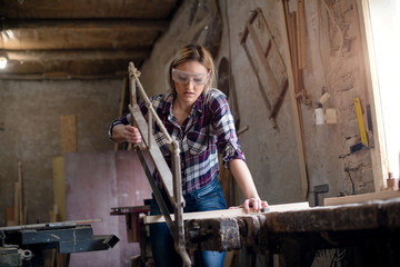 Fototapeta na wymiar Woman is cutting wood manual