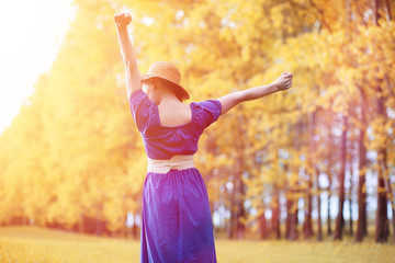 Young beautiful girl in dresses on nature. A girl in a hat walks