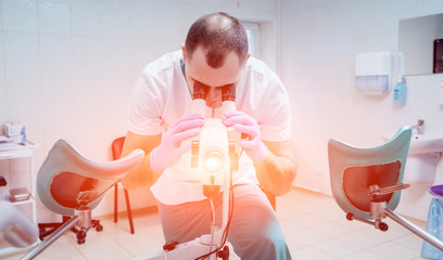 Gynecologist working with colposcope in clinic.