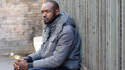 Pensive and sad Black african man alone in the city- poverty, sadness, migration