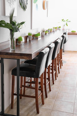 Modern cafe interior with wooden counter and chairs