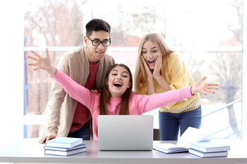 Excited students finding out their excellent grades for examination indoors