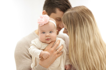 Young parents with baby on light background