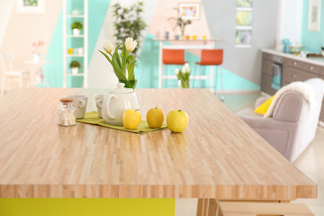 Wooden table with cups and teapot on kitchen