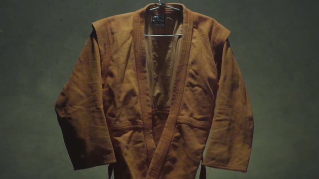 Martial arts, red hanging kimono closeup. Red sports uniform or kimono for karate, sambo and jiu jitsu