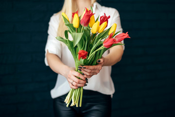 yellow and pink tulips girl holding hands on black background