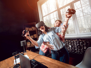 The young man with girlfriend plays a game at the office.