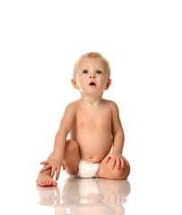 Infant child baby boy toddler sitting naked in diaper looking up 