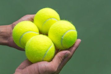 Tennis balls in hand.