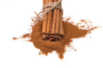 Cinnamon sticks tied with a rope on cinnamon powder, isolated on white background.