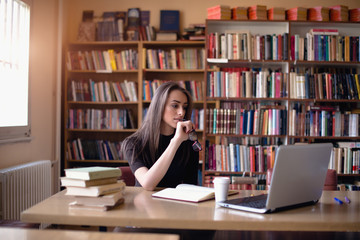 Caucasian female student studying in library