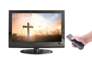 Good Friday concept: Human hands holding remote video and monitor display the cross on sunset on...