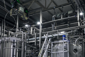 Stainless steel brewing equipment : large reservoirs or tanks and pipes in modern beer factory. Brewery production concept